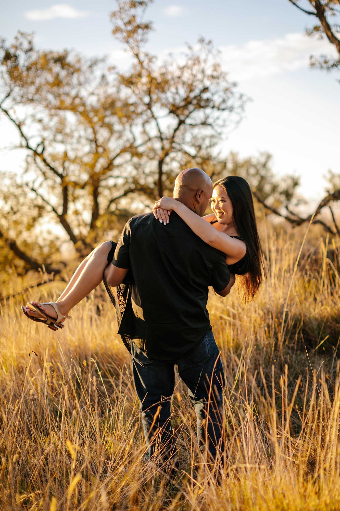 image of man carrying his girlfriend in the grass