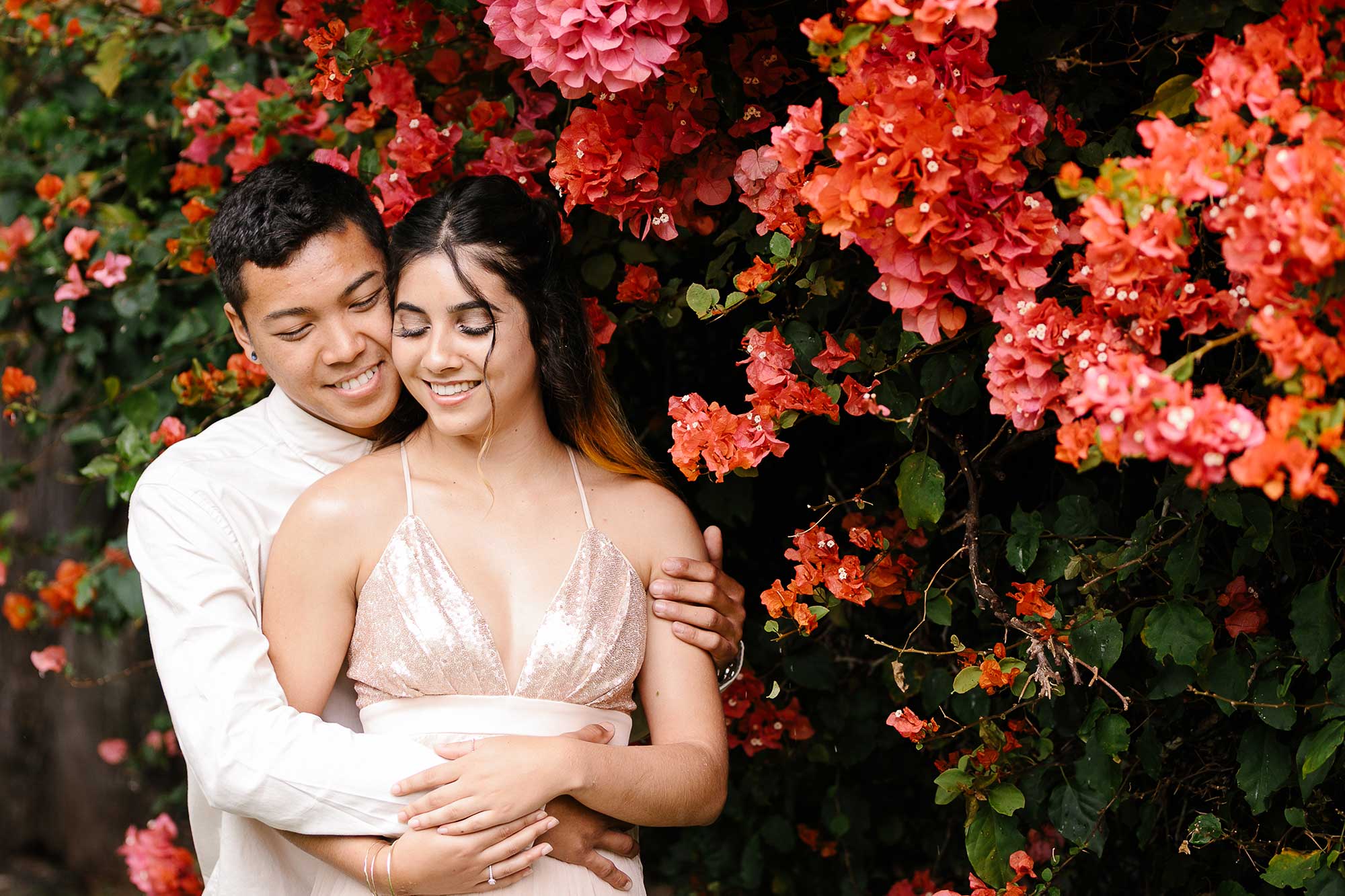 image of couple hugging next to bougainvillea