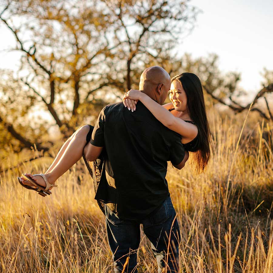 image of man carrying his girlfriend in the grass