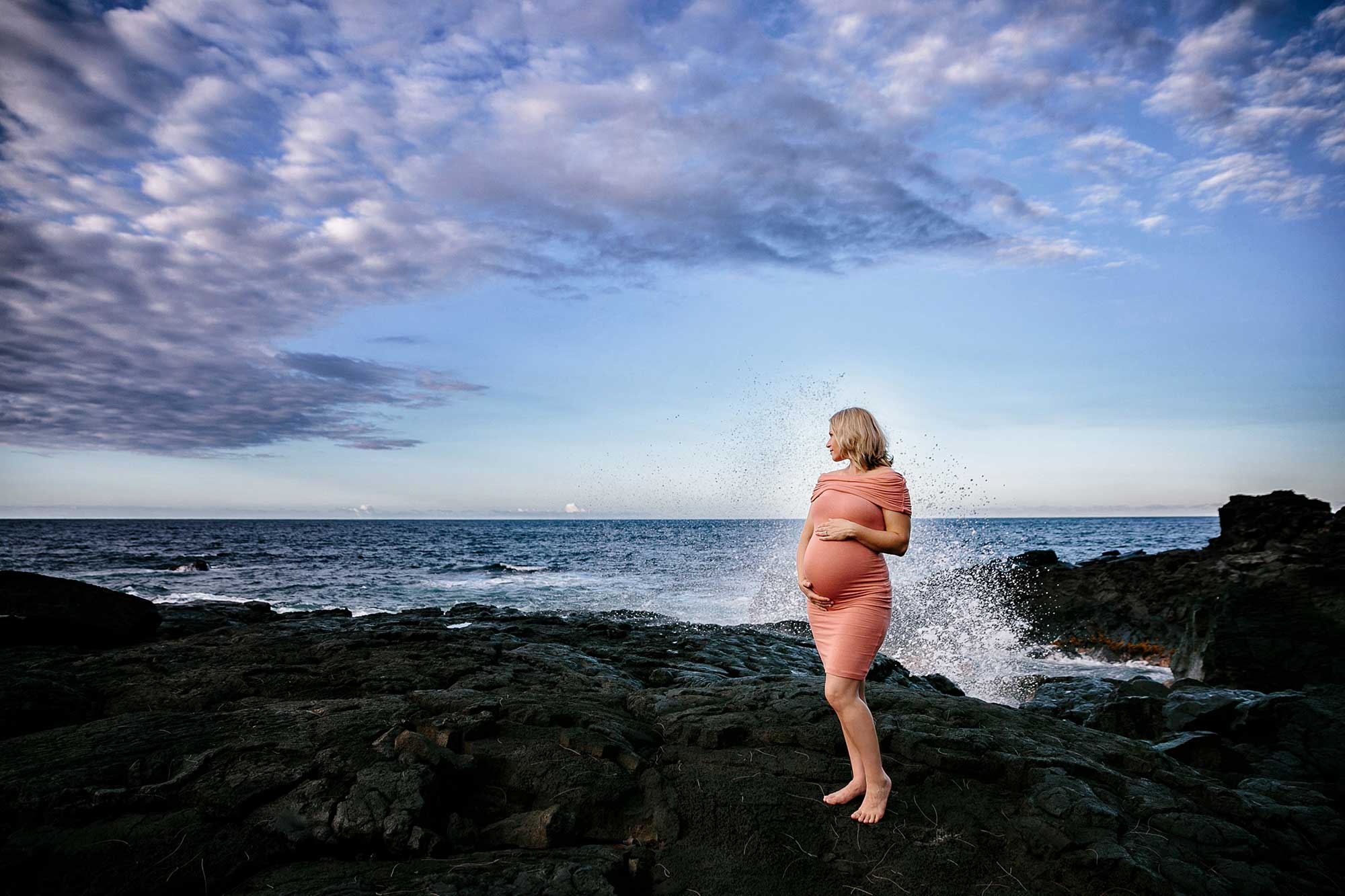 image of pregnant wife on the rocks next to the ocean