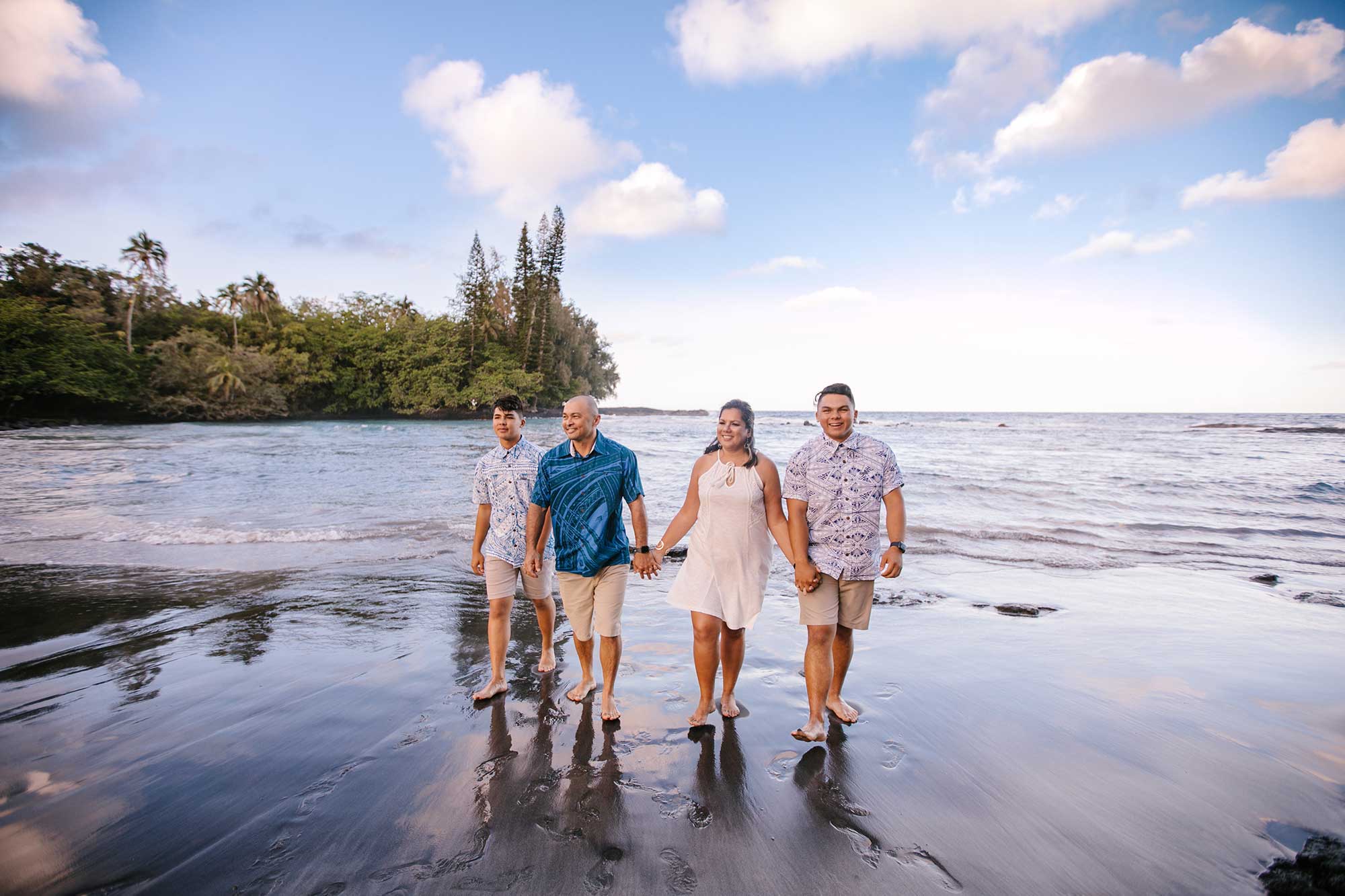 image of couple and their two sons walking on the beach
