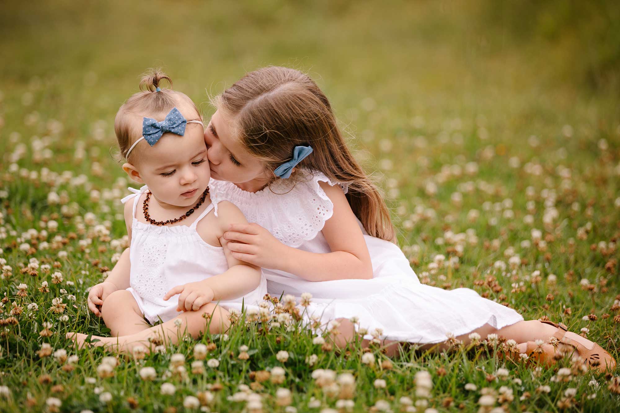 image of two small sisters together in a meadow