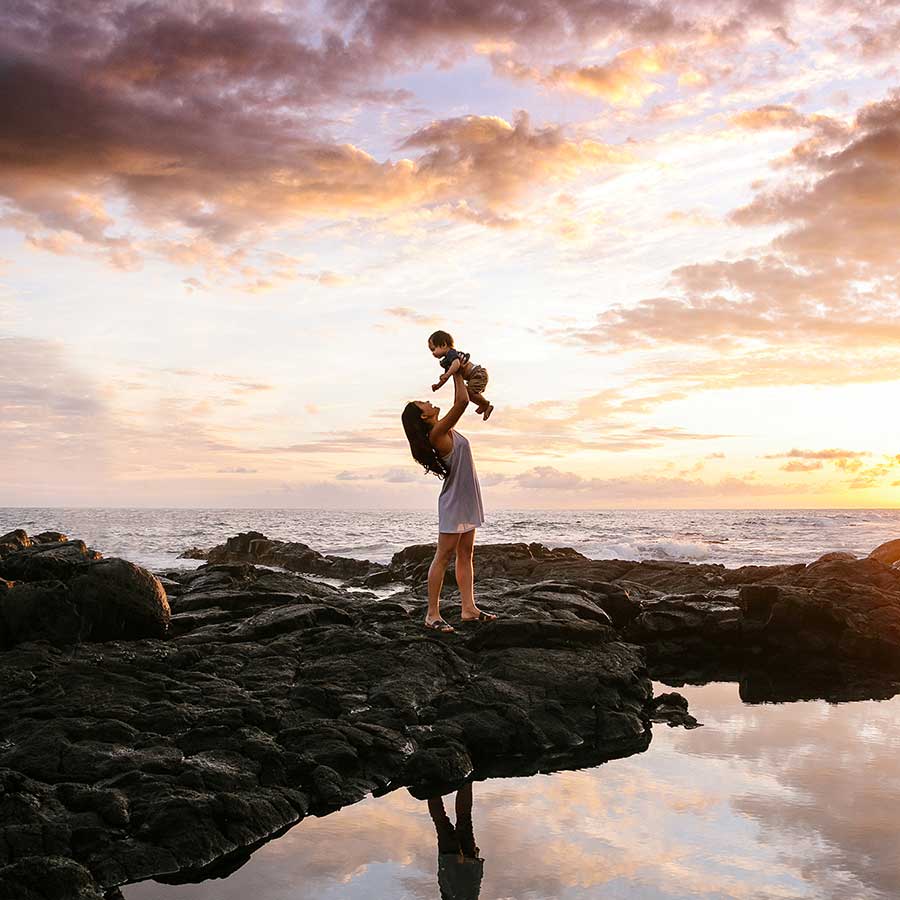 image of mother and young son at the beach during sunset
