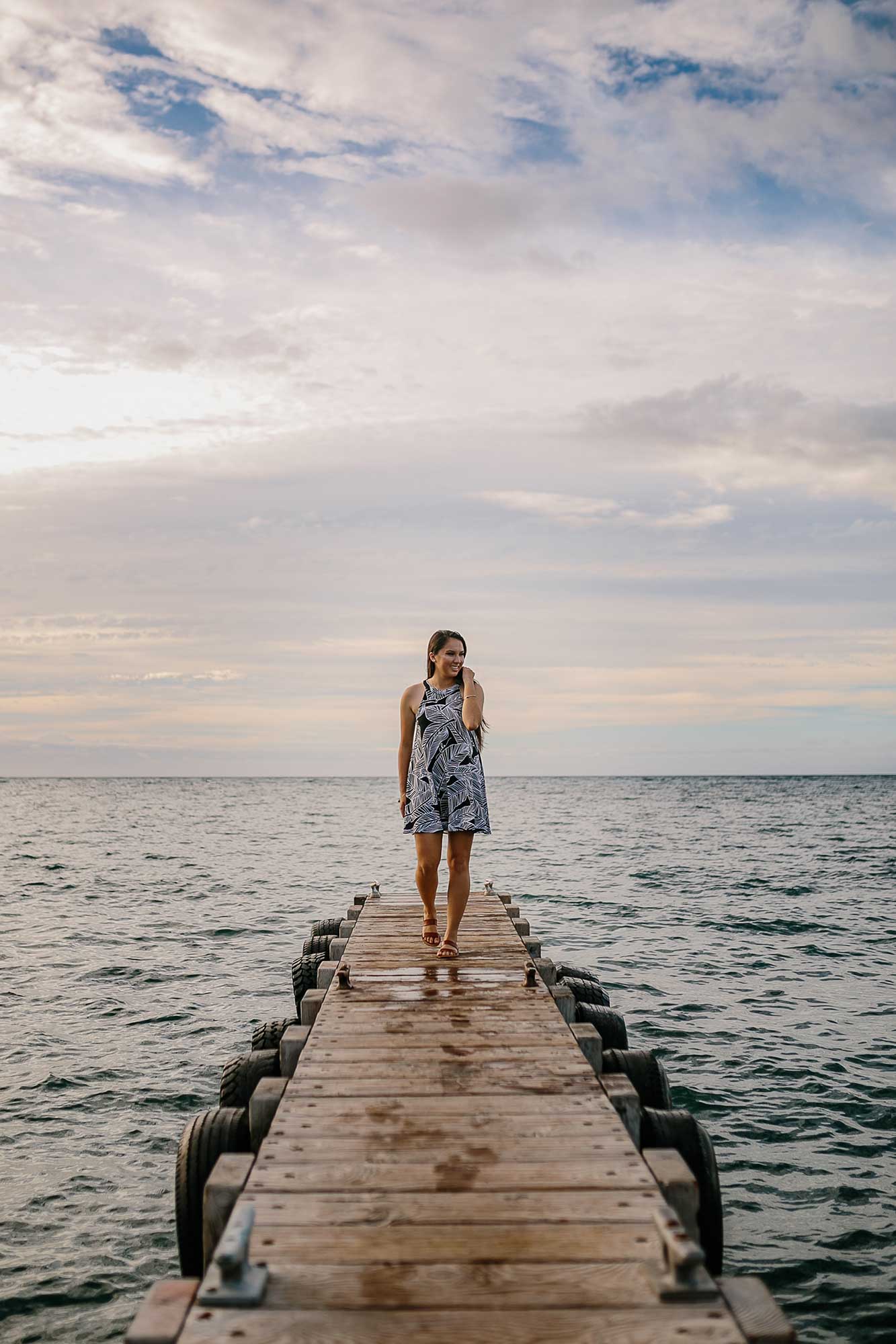 image of a senior portrait of a girl walking on a pier