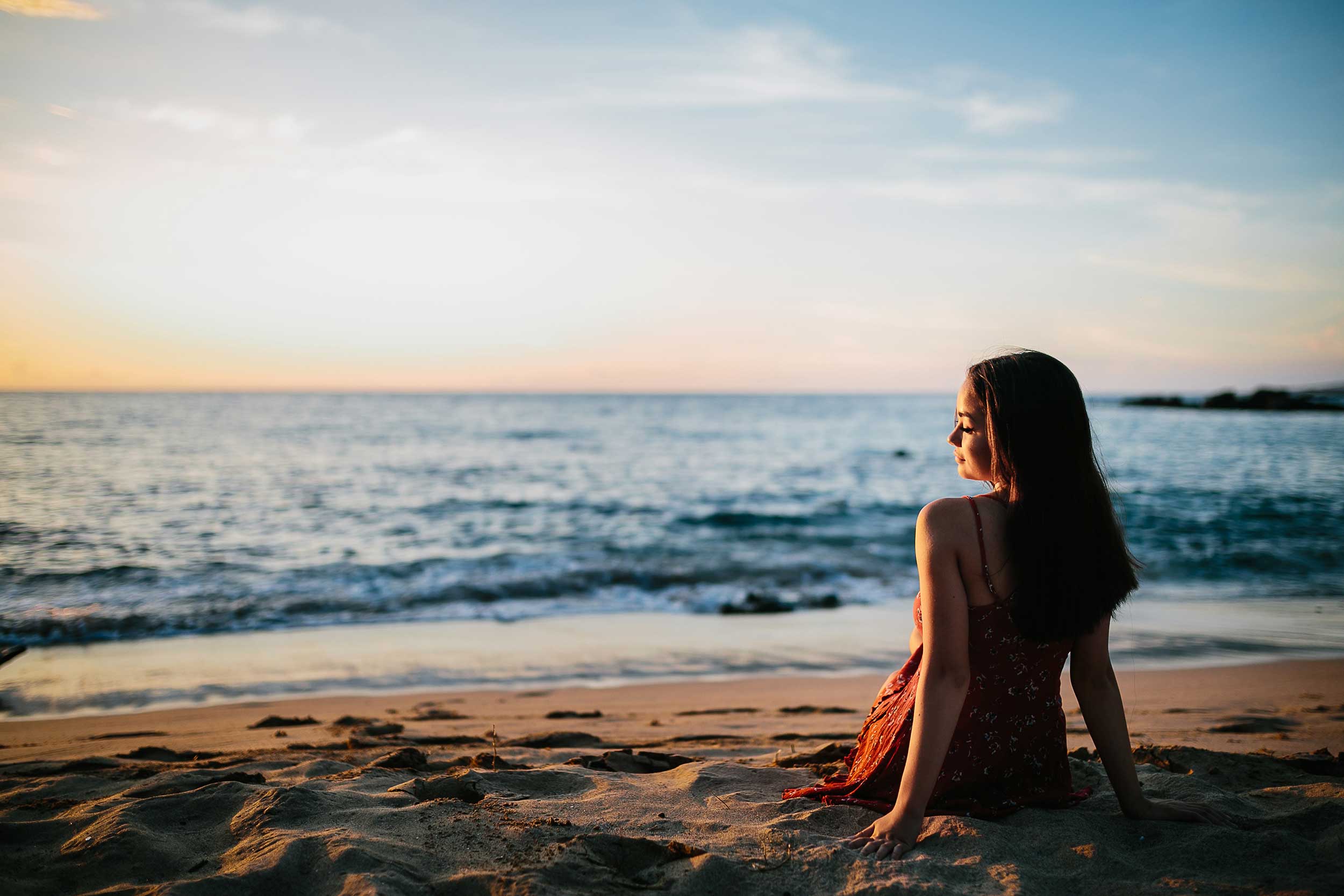 image of a senior portrait of a girl at the beach watching the surf