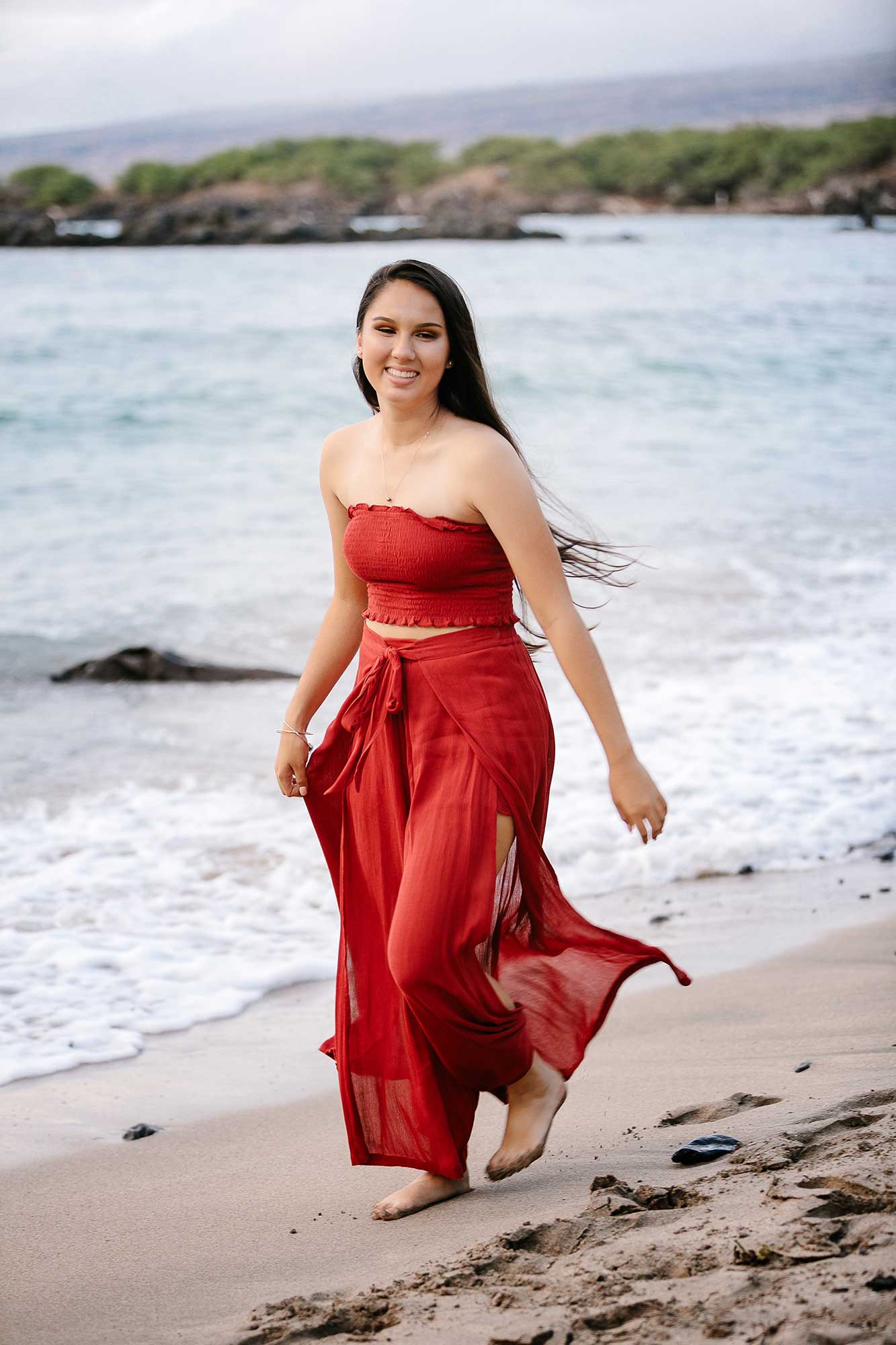 image of a senior portrait of a girl wearing a red dress on the beach