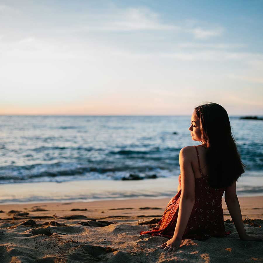 image of a senior portrait of a girl at the beach watching the surf