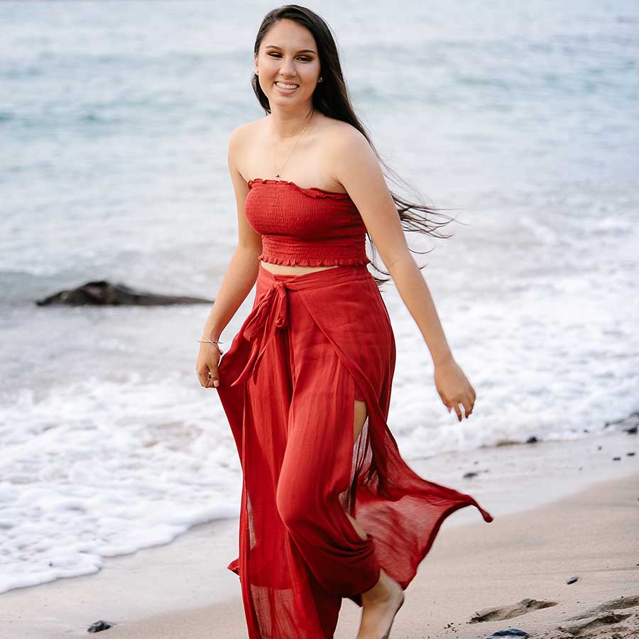 image of a senior portrait of a girl wearing a red dress on the beach