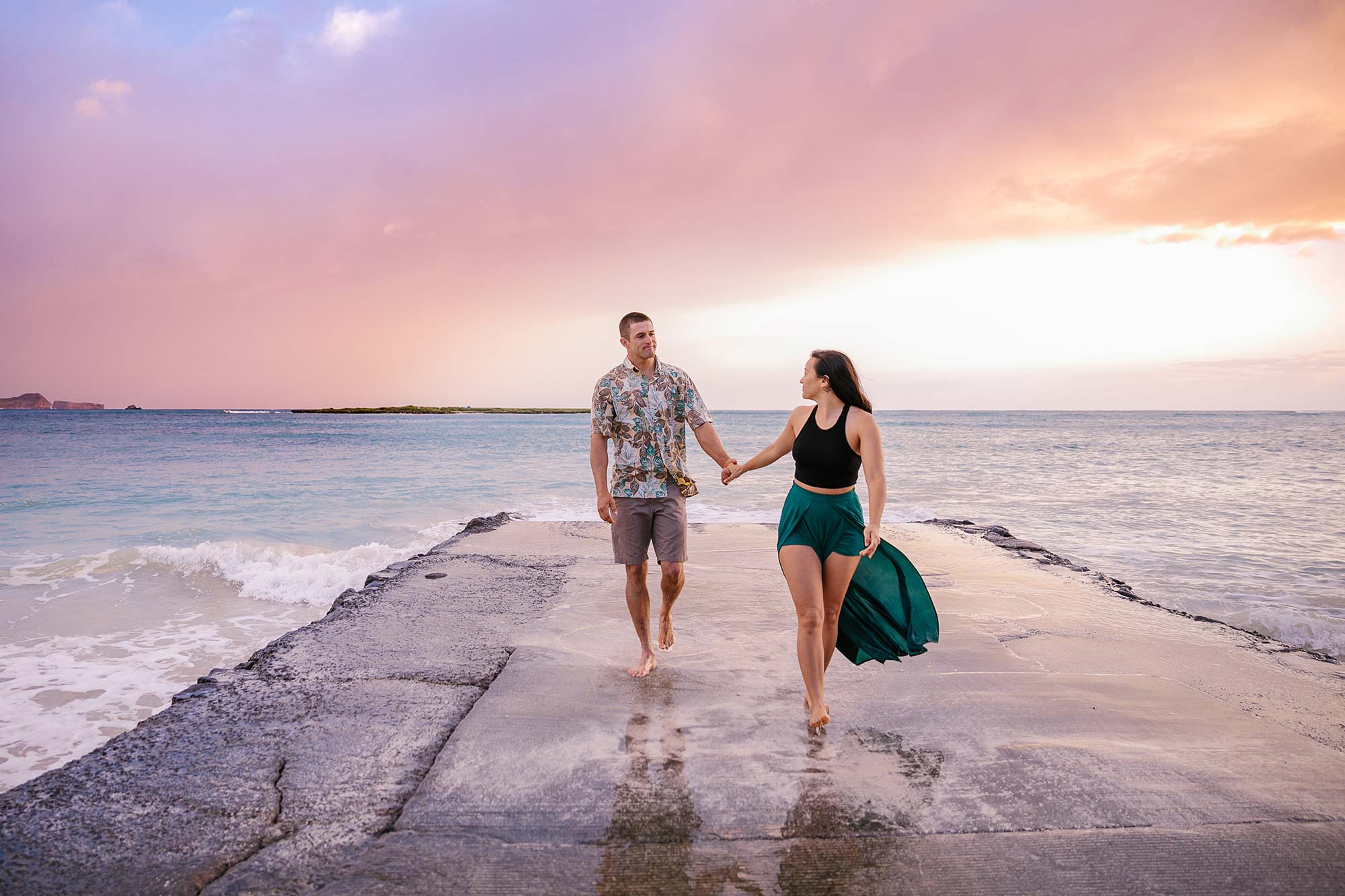 image of engagement couple walking near the ocean